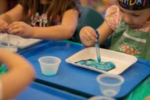 Children painting in the child development instructional lab